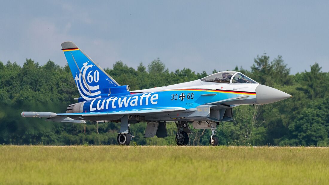 A Eurofighter Typhoon in a blue and white special scheme on a runway, its canard foreplane mounted high and far forward near the nose